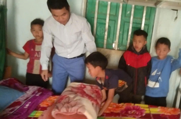 Thầy giáo hướng dẫn các em học sinh ở nội trú cách gấp chăn màn